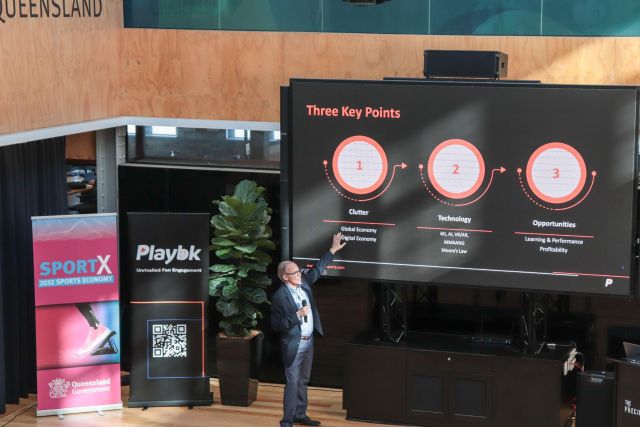 Main in suit pointing to a presentation on a screen with three circles